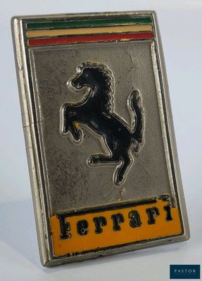 un gros plan sur un emblème Ferrari sur une surface blanche