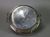 a silver plate with a wire around it on a table