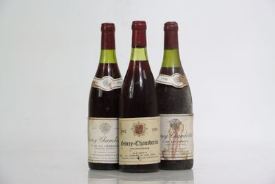 three bottles of wine are lined up on a reflective surface