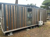 a tiny house that is on wheels in the grass