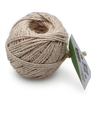 la pelote de ficelle de jute repose sur une surface blanche