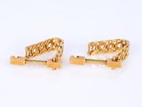 two pairs of gold cufflinks on a white background