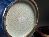 a blue vase sitting next to a wooden bowl