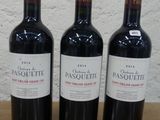 trois bouteilles de vin posées sur une table en bois