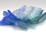 a glass bowl that has a blue flower inside of it