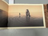 an open book with a picture of a woman and a man in the water