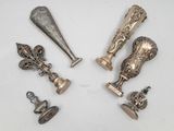 Plusieurs pièces d'argenterie ancienne sont exposées sur un support blanc