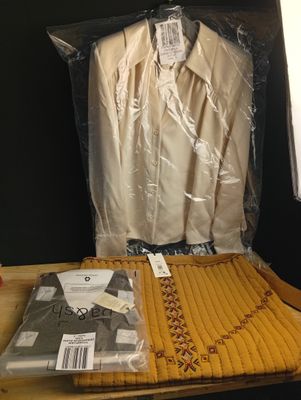 un sac de vêtements posé sur une table à côté d'une paire de chaussures