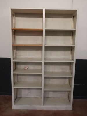 une bibliothèque blanche à deux étagères, placée dans un coin