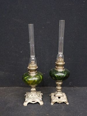 paire de bougeoirs en verre vert rehaussés de touches dorées sur fond noir