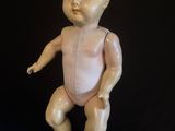 an old porcelain baby doll sitting on top of a black surface