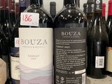several bottles of red wine are lined up on a counter