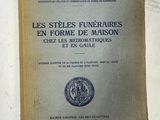 un vieux livre posé sur une table à côté d'un mur blanc