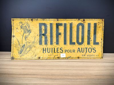 an old yellow and black sign sitting on top of a wooden table