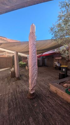 une photo d'une terrasse surmontée d'un grand parasol