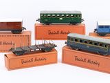 five toy trains on display on a white surface