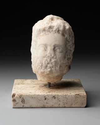 une tête d'homme antique posée sur un socle en marbre