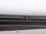 a close up of a rifle with a wooden barrel on a white background
