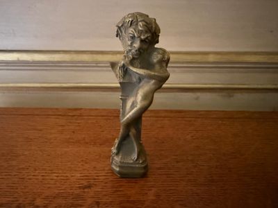 a small statue of a woman sitting on a table