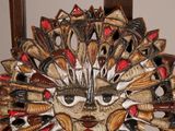 a decorative mask made out of shells on a chair
