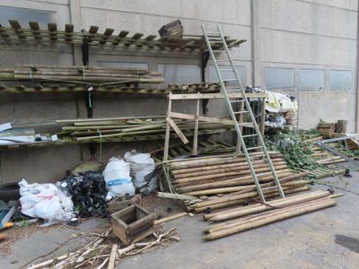 a pile of bamboo sticks sitting on the side of a building