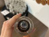 someone is holding a glass with a liquid inside of it