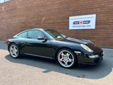 a picture of a black porsche parked in front of a building