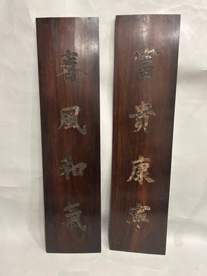 two wooden plaques with asian writing on them on a white background