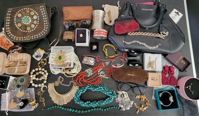many different types of purses and jewelry on the table