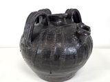 a black vase that is sitting on a table