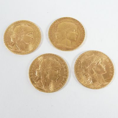 quatre souverains d'or posés sur une surface blanche, sur fond blanc