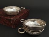 a silver bowl and a silver bowl on a wooden stand