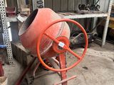 une bétonnière rangée dans un garage avec d'autres outils