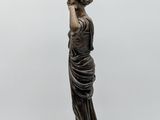 an image of a statue of a woman holding a lamp on a table