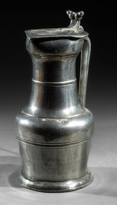an image of a silver vase with a handle on a table