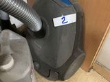 a vacuum that is sitting on the floor next to a door