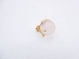 a white stone ring with a gold band on a white surface