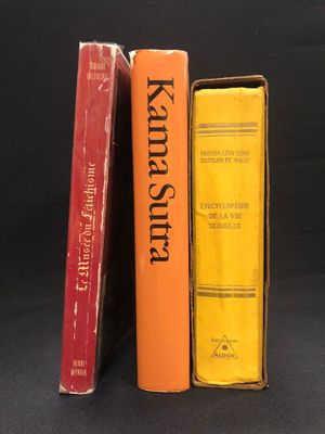 trois livres sont empilés les uns sur les autres sur une surface noire