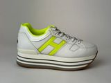 a pair of white sneakers with neon yellow accents on the sole