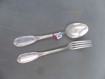 two silver spoons and a fork on a table