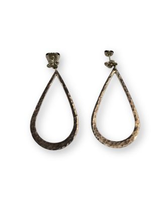 une paire de boucles d'oreilles en argent martelé en forme de larme sur fond blanc