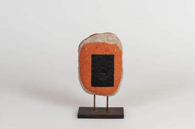 an orange and black stone with a black square on it