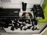 a glass shelf with a keyboard, camera, and other electronics on it