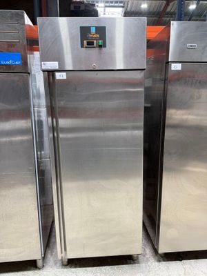 three stainless steel refrigerators are lined up in a warehouse