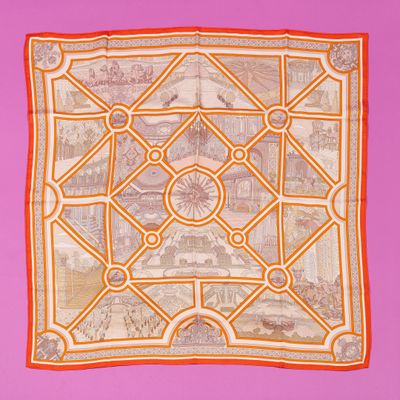 an orange and white square scarf with a picture of a city on it