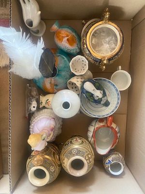 une boîte en carton remplie d'un assortiment de vases et d'autres objets décoratifs