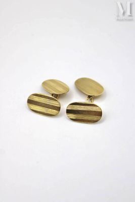 a pair of gold cufflinks on a white background