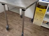 une table en acier inoxydable sur roulettes dans une pièce