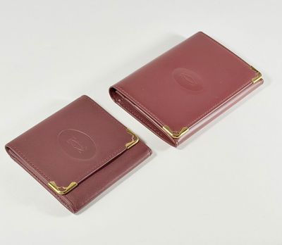 deux portefeuilles en cuir rose posés sur une surface blanche