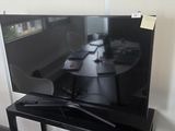 un téléviseur à écran plat posé sur un support dans le coin d'une pièce